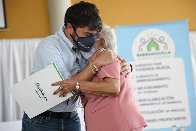 Alcalde Pumarejo abraza a mujer adulta mayor que recibió con ciudadana que Alclde abraza a adulta mayor que recibió título de propiedad de su vivienda.