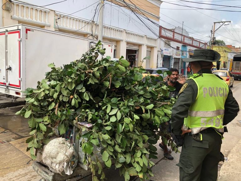 Policia dialogándo con carretillero con desechos.