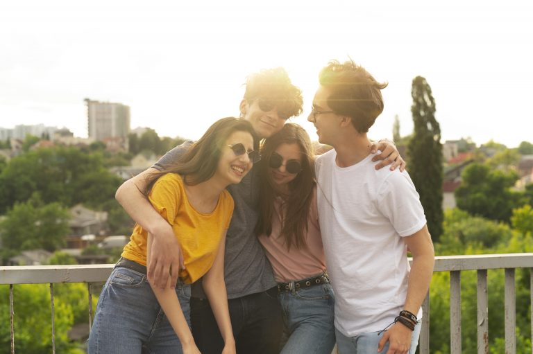 Grupo de amigos abrazándose al atardecer