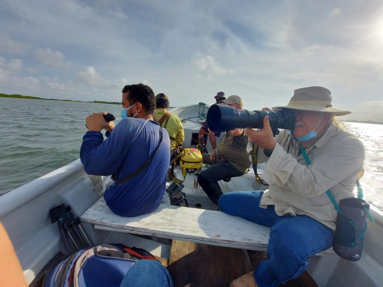 Fotografos en embarcación en la cienaga tomándo foto.