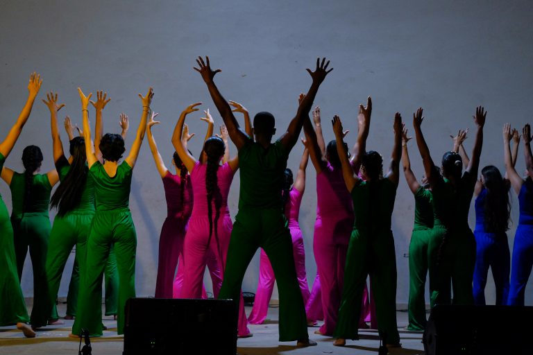 Grupo de danzantes de esplada con los brazos arriba