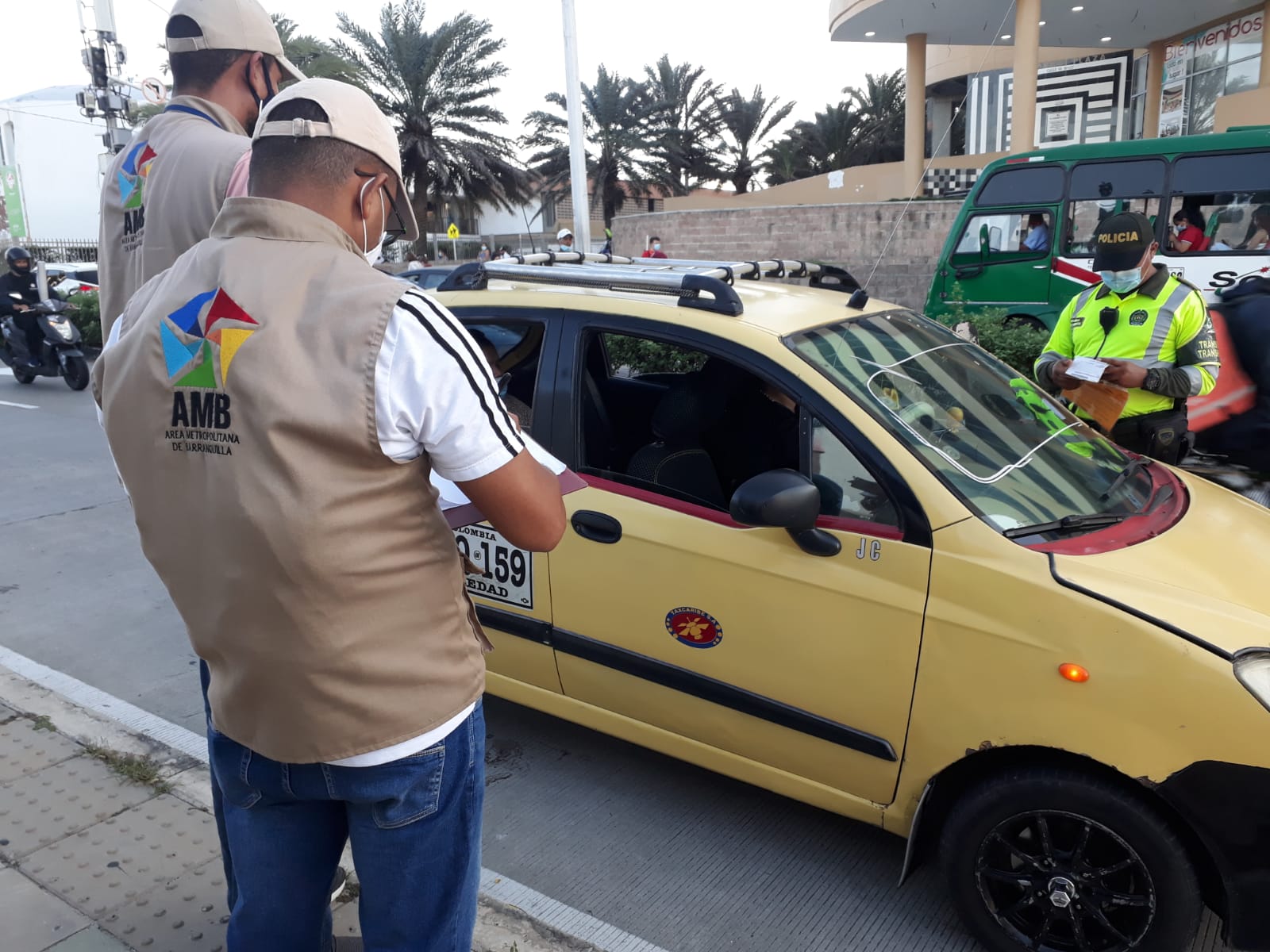 Funcionario del ärea Metropolitana de Barranquilla frente a un taxi.