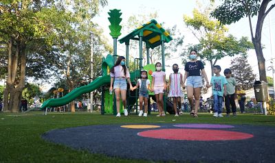 Niños caminando zona infantil de parque.