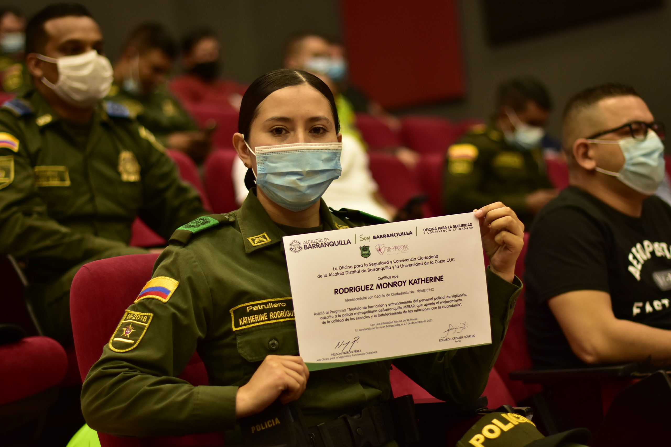 Mujer policia muestra diploma.