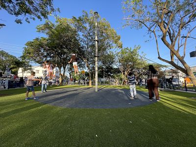 Niños jugando en zona infantil de parque.