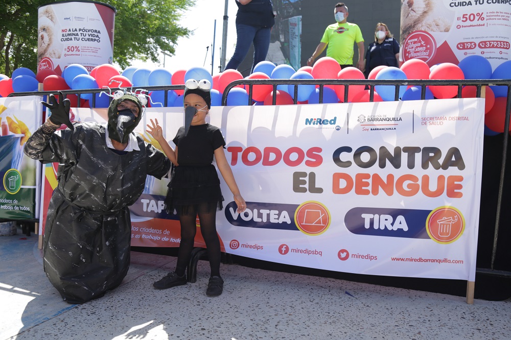 Niña y adulto disfrazados en la movilización social conra el Dengue