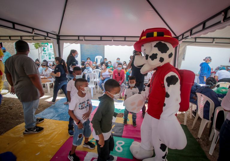 Imagen de niños en actividad recreativa con inflables y personal de la alcaldía