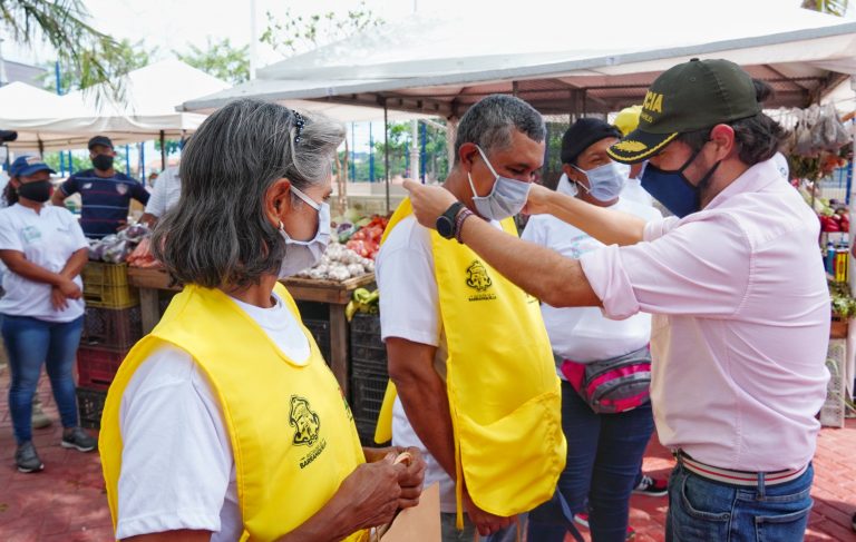 Imagen del alcalde Pumarejo en una plazoleta de mercado a tu barrio con un grupo de vendedores