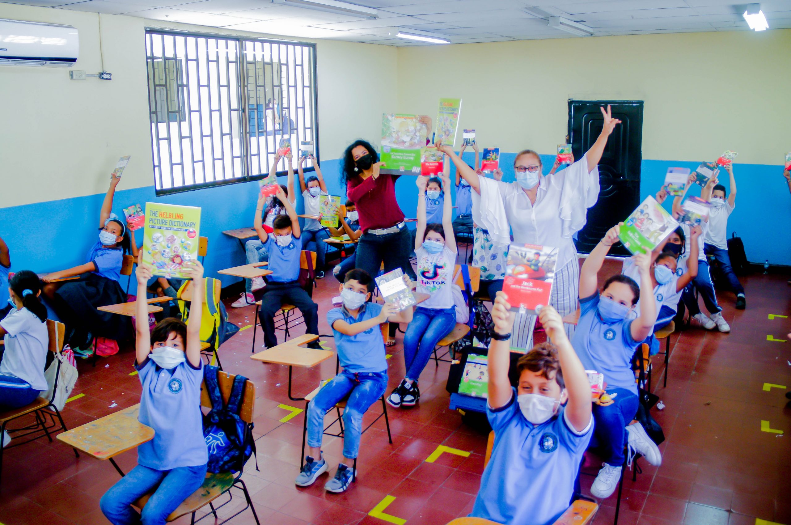 Estudiantes muestran cartillas de inglés