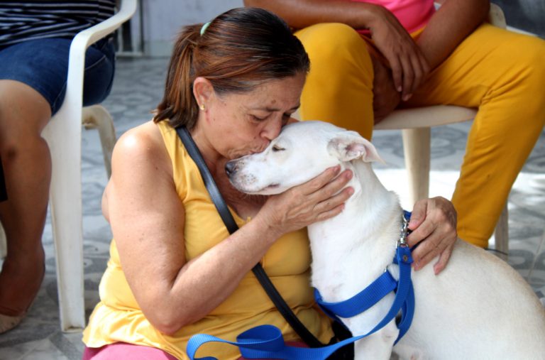 Mujer besa a su mascota canina en jornada de bienestar animal