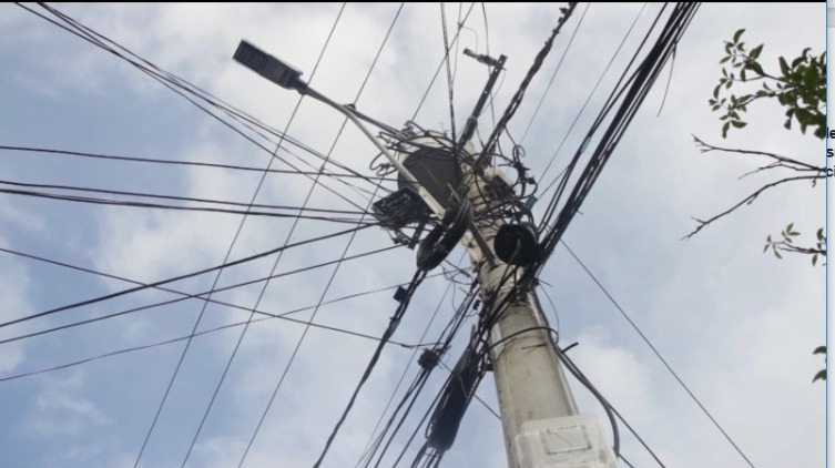 Telarañas de cables de luz en un poste