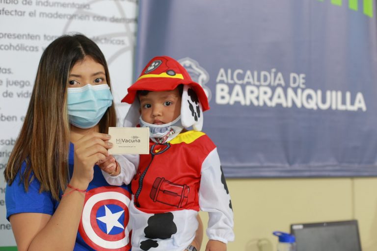 Mamá y su hijo sostienen un carnet de vacunación