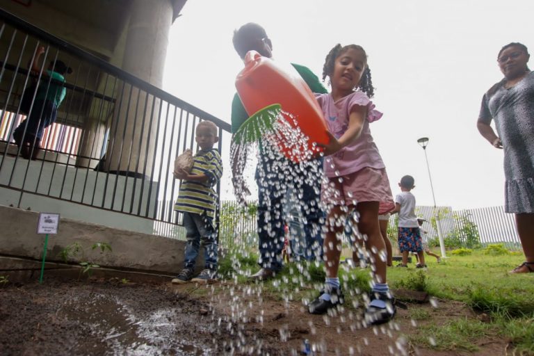 Niños disfrutan regando plantas