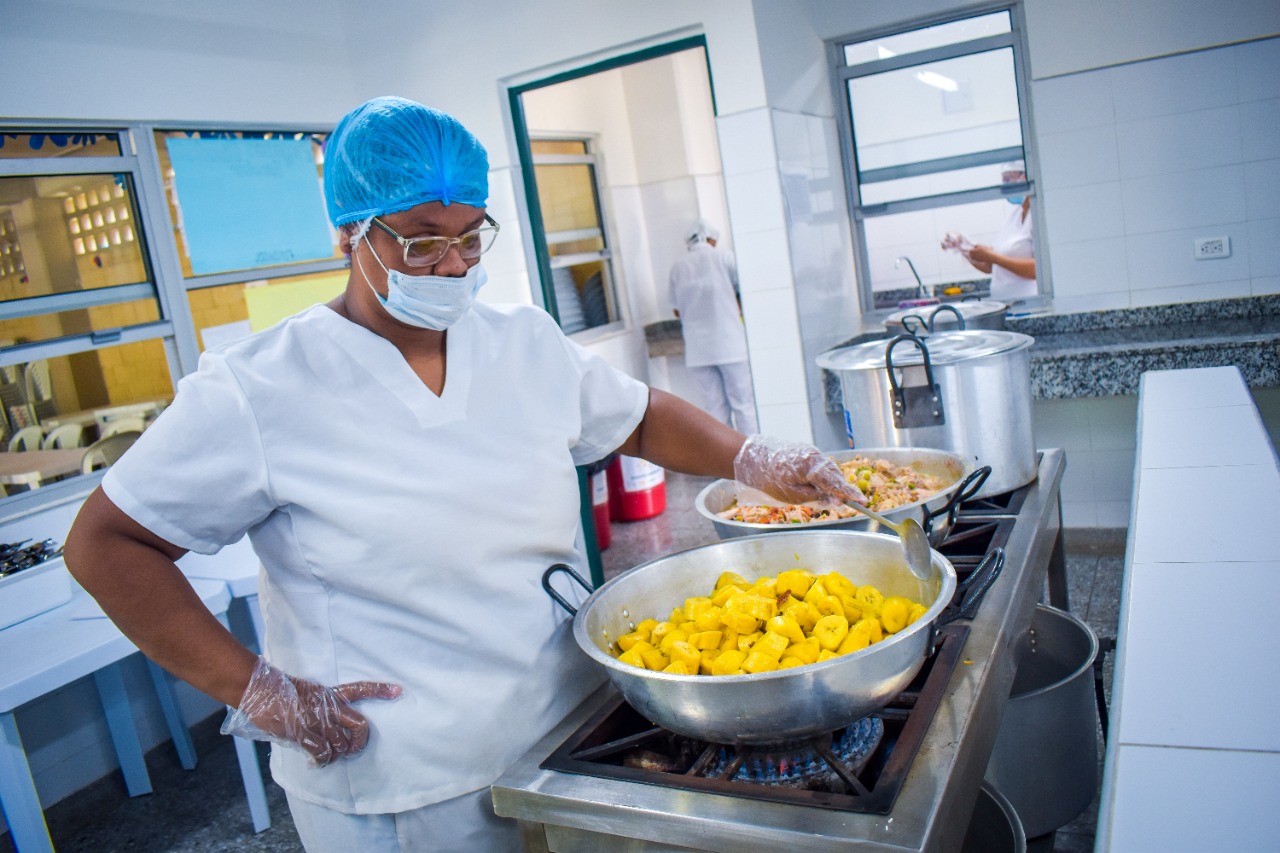 Manipuladora prepara alimentos en cocina escolar