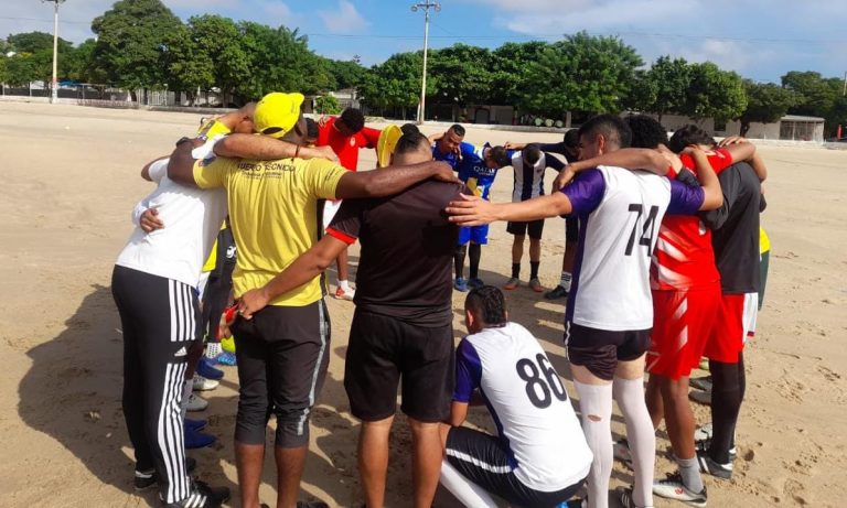 Grupo de jóvenes abrazados en una cancha