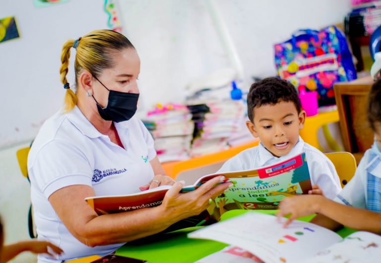 Maestra y alumno leyendo una cartilla