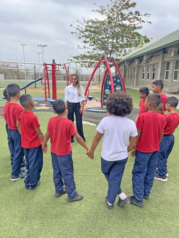 Leyla Yidos jugando con estudiantes en parque infantil