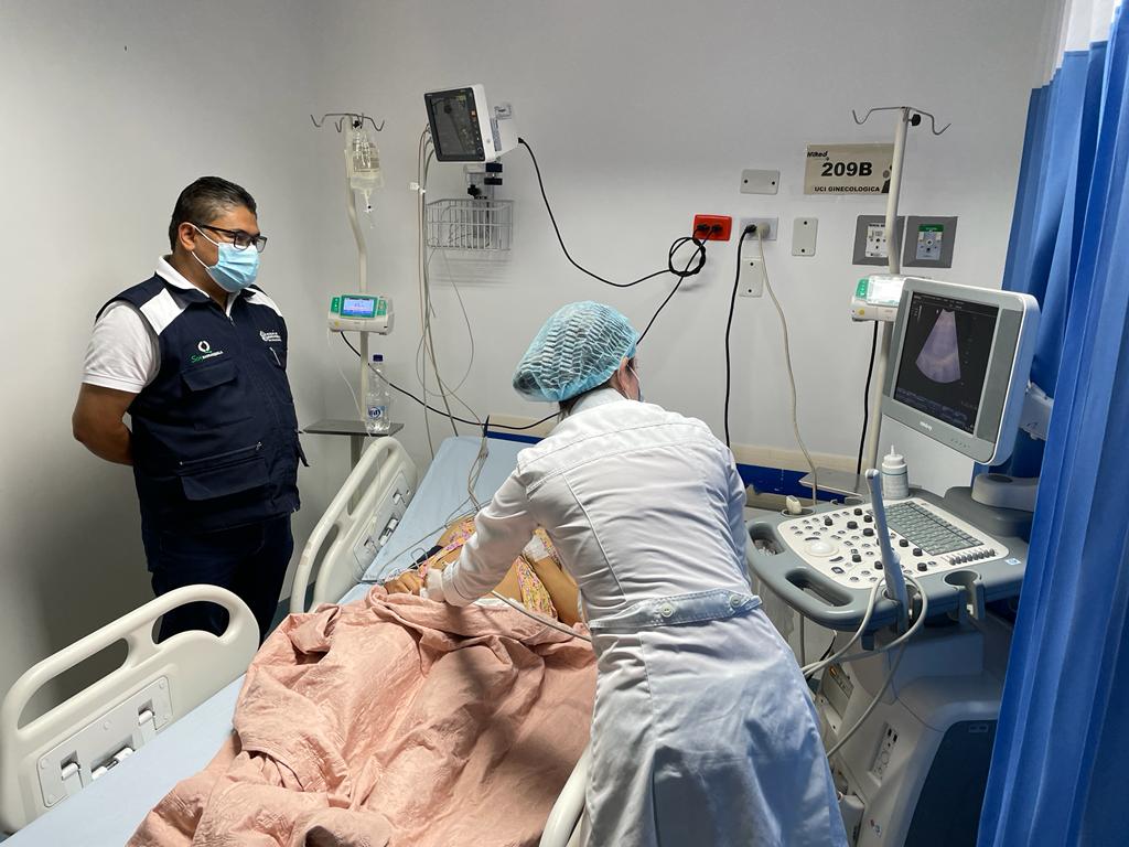 Habitacion de hospital con un paciente siendo atendido por personal medico