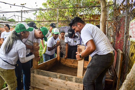 Grupo de personas elaborando pacas de digestoras en el barrio La Paz.