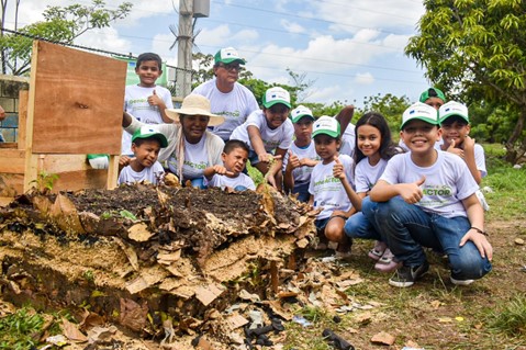 Grupo de adultos y niños en la paca de digestora en Villas de San Pablo.