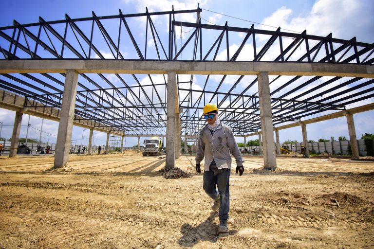 obrero caminando en construcción de mercado Sredni