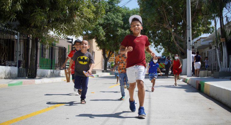 Niños corriendo por la calle pavimentada