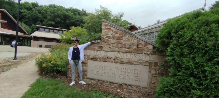 Joven posando en entrada de Universidad PUDE en Estados Unidos