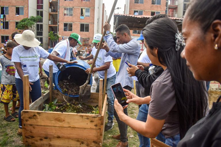 Grupo de personas elaborando paca de digestora en Las Gardernias.