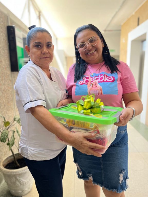 mujer recibiendo ancheta de manos de funcionaria