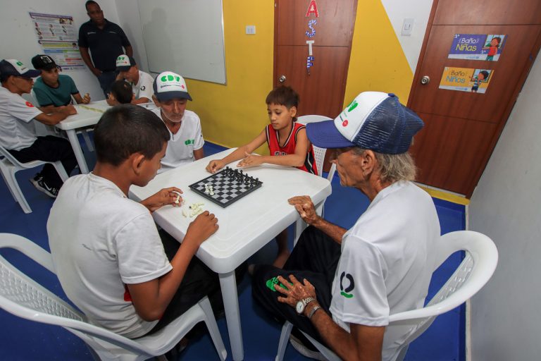 Adultos mayores y niño jugando Ajedrez