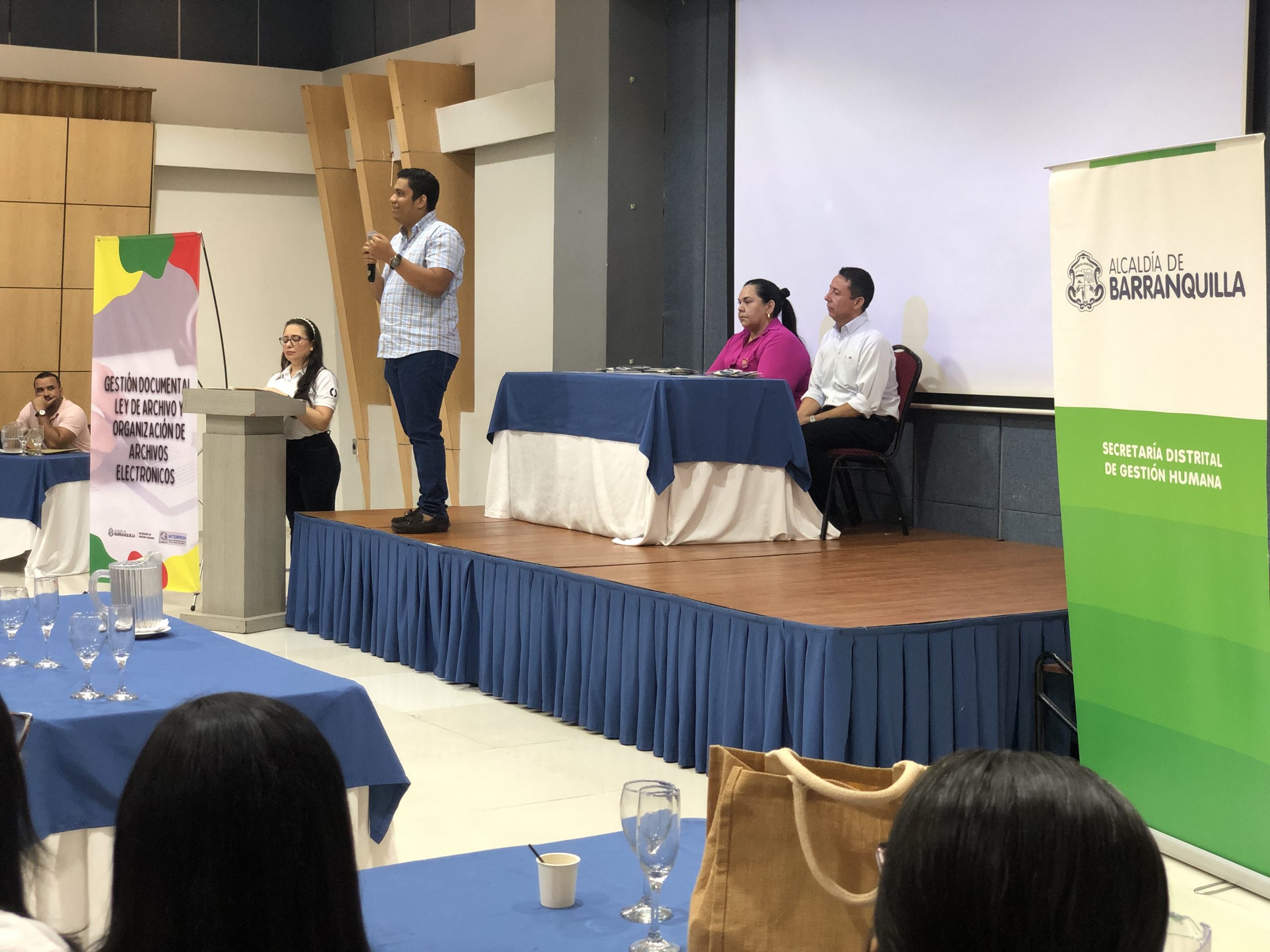 Hombre hablando en tarima en culminación de jornada académica