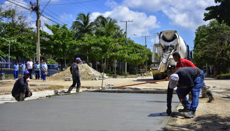 Maquina con obreros pavimentando una calle