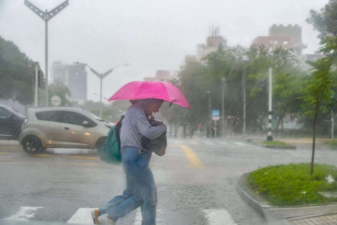 Persona con paraguas protegiéndose de la lluvia en la calle