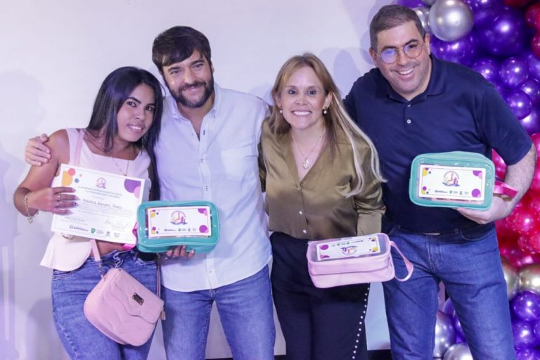 Mujer con certificado y kit de emprendimiento en la mano junto con alcalde Pumarejo y dos funcionarios de la Alcaldía Distrital