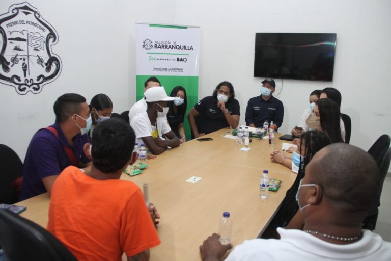 Grupo de personas interactuando en mesa redonda con funcionarios de la UCJ 