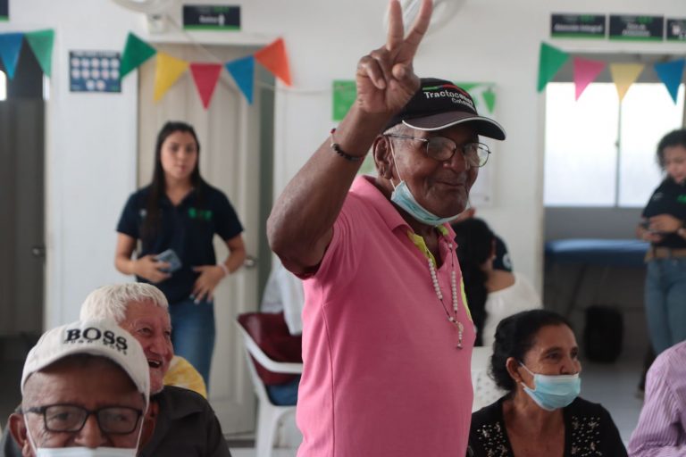 Adulto mayor haciendo el signo V con la mano