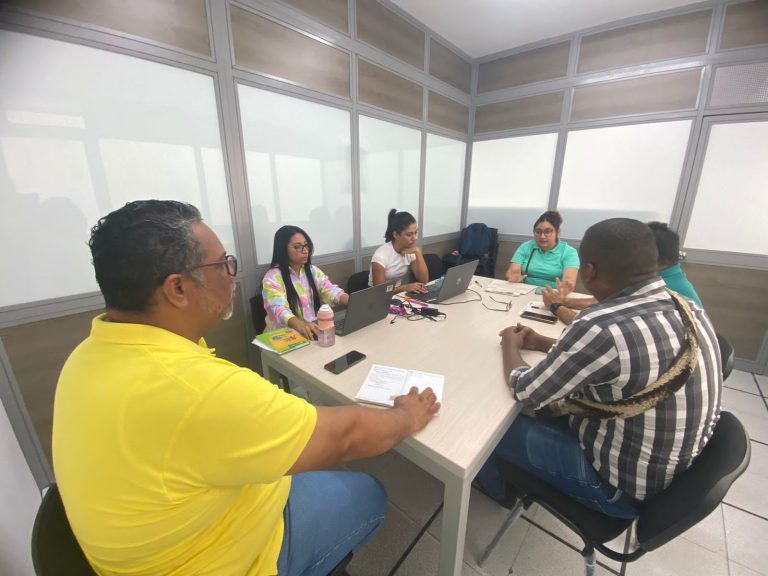 Personas reunidas en mesa de capacitación 