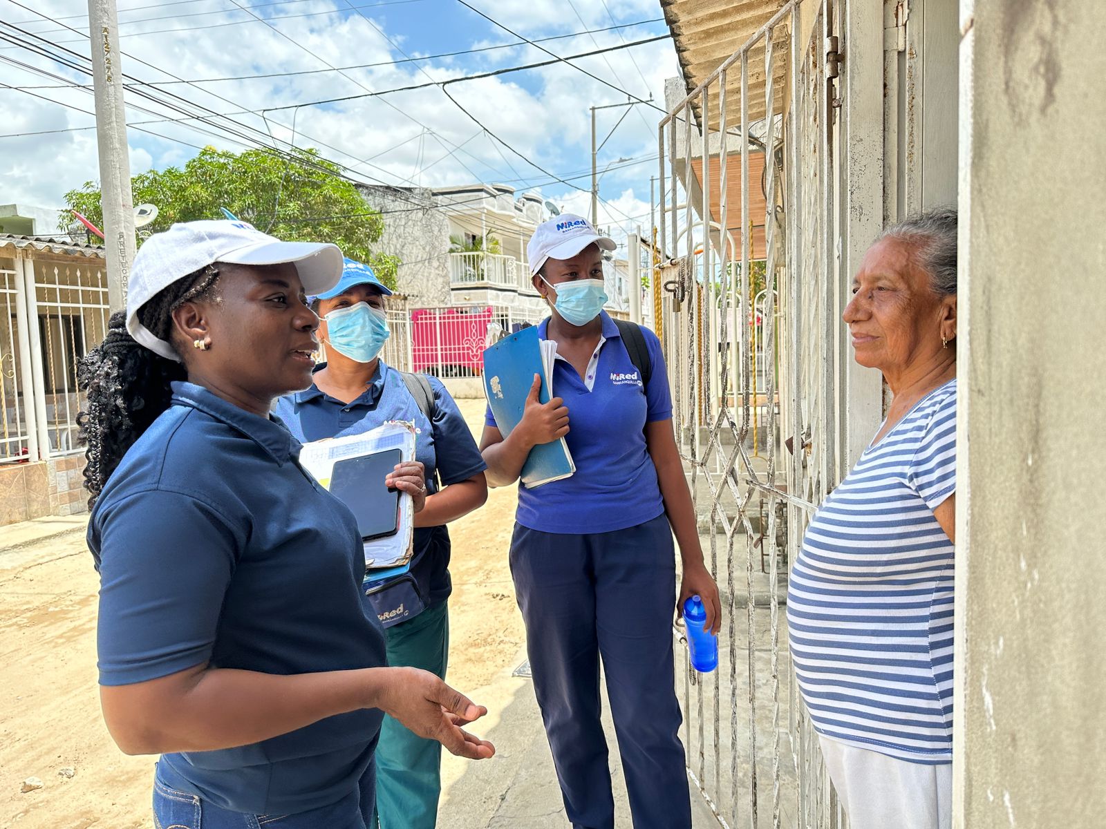 Caminante de salud dialogando con vecina de un barrio sobre prevención del dengue