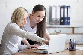 Dos mujeres trabajando frente a un computador