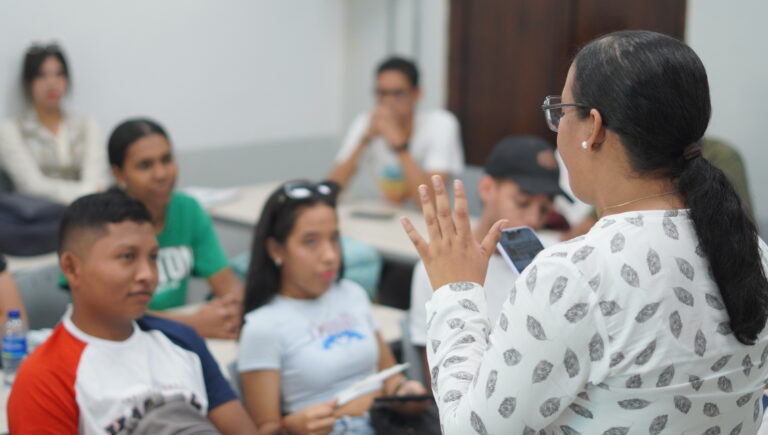 Mujer dirigiéndose a jóvenes 