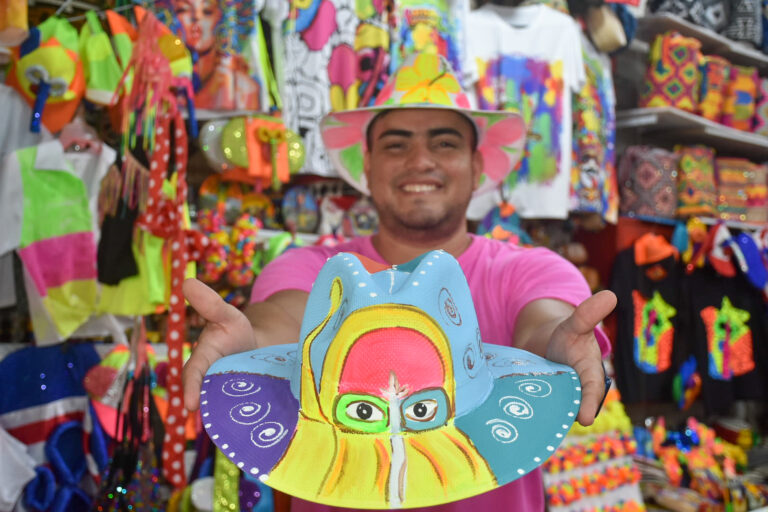 Vendedor muestra un sombrero en un stand de la Feria