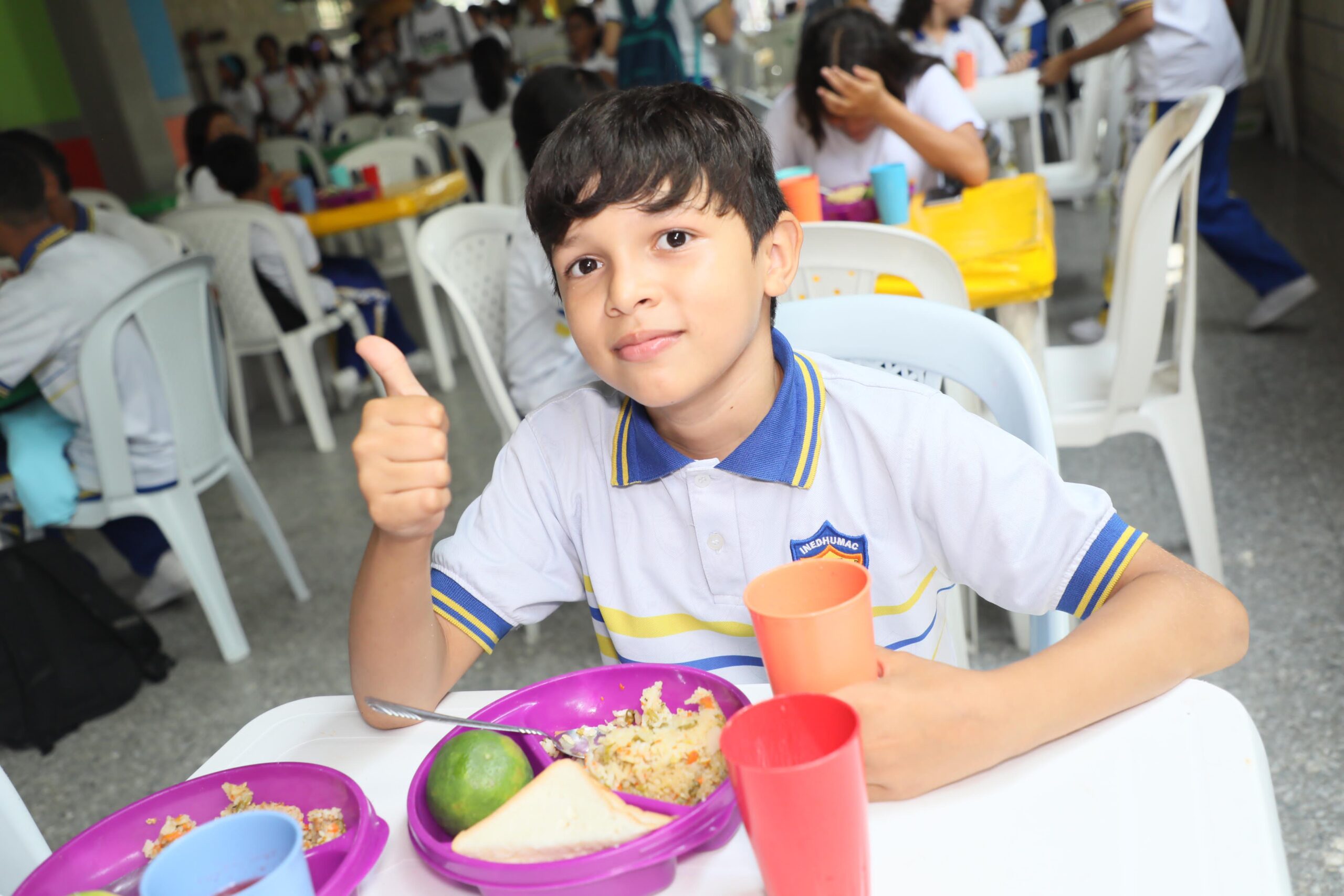 Niño en comedor de colegio almorzando.