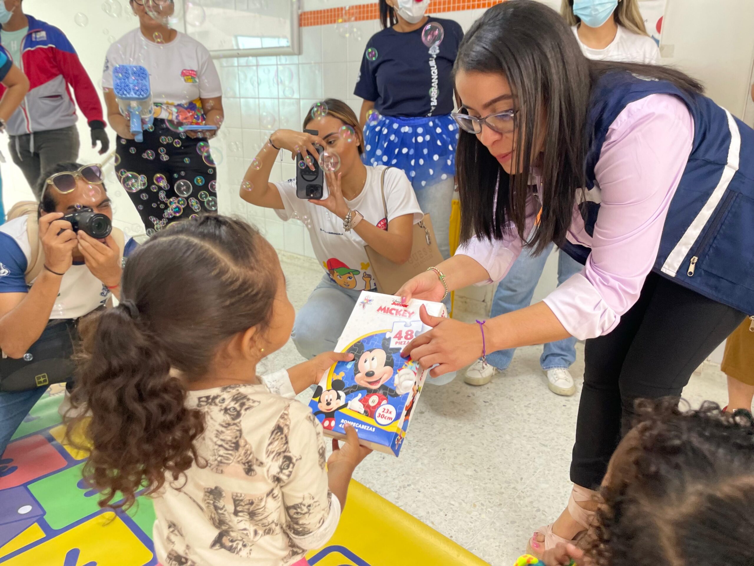 Secretaria de Salud entregando libro a niño