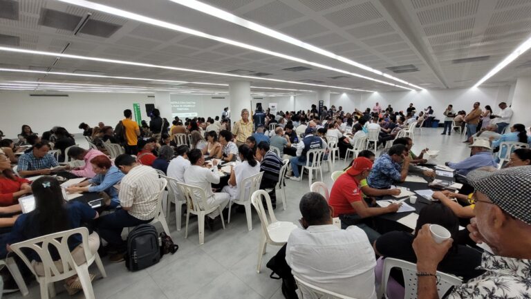 Ciudadanos reunidos en auditorio en mesas de trabajo 