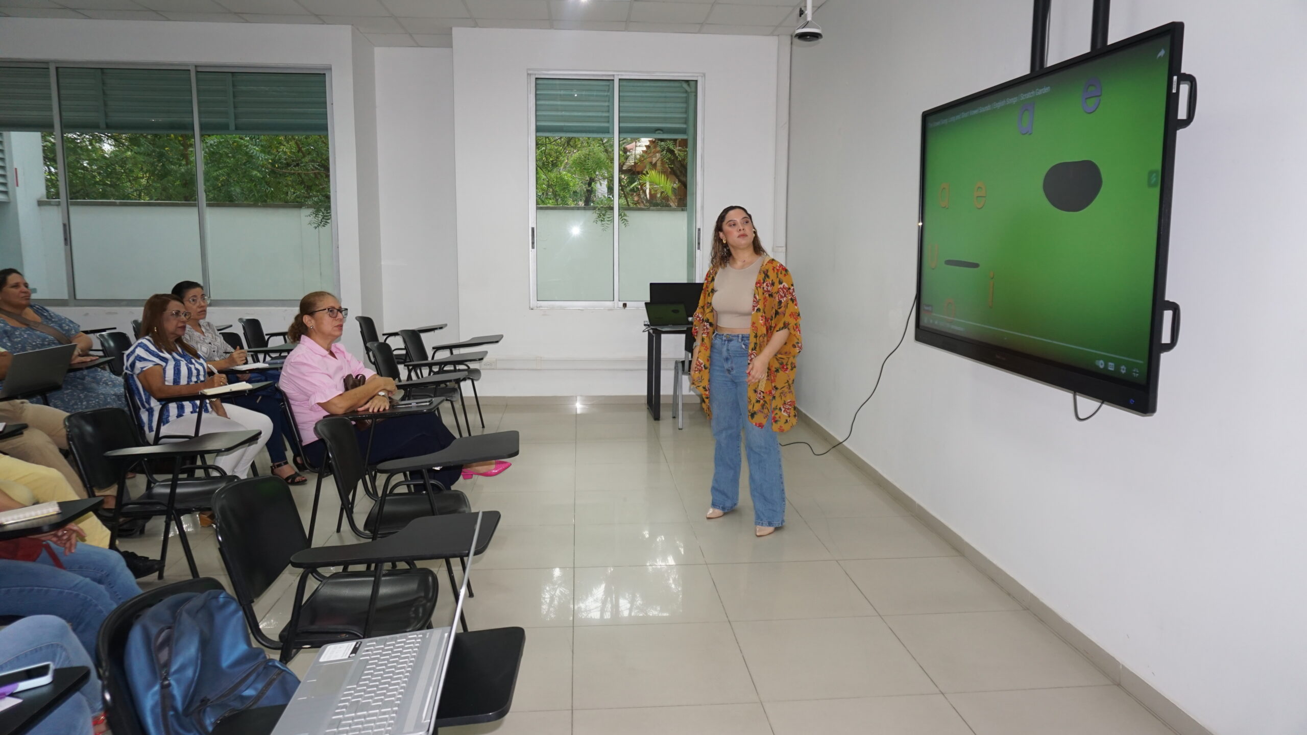 Docente dirigiéndose a grupo de docentes en salón de clase