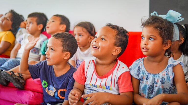 Grupo de niños observan atentamente a su maestro en un salón de clases.