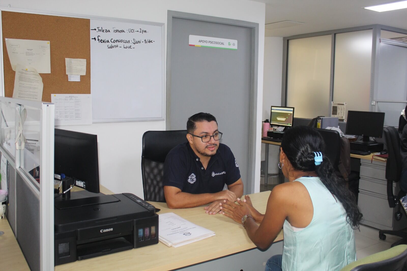 Funcionario alcaldía de Barranquilla atendiendo a usuaria.