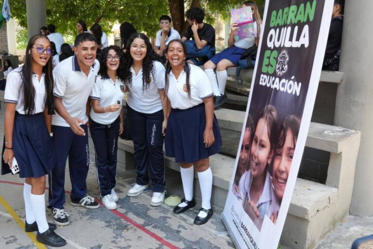 Jóvenes de instituciones educativas sonrientes frente a pendón de Alcaldía