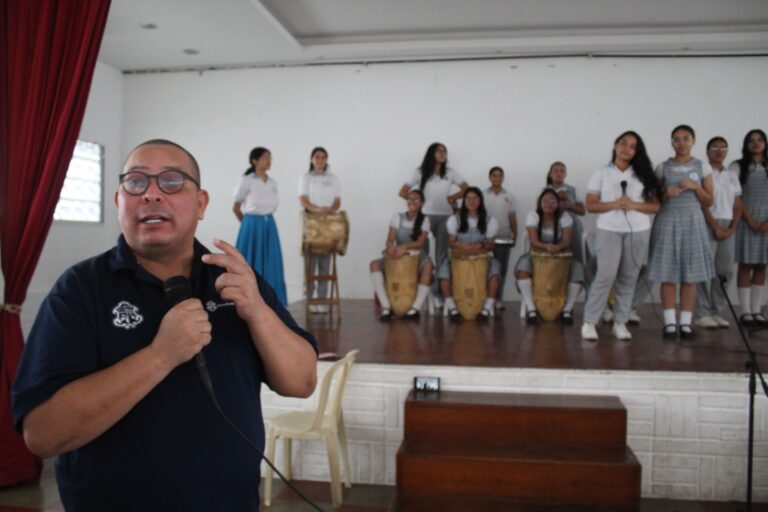 Secretario de Cultura en primer plano al fondo grupo de música estudiantil 