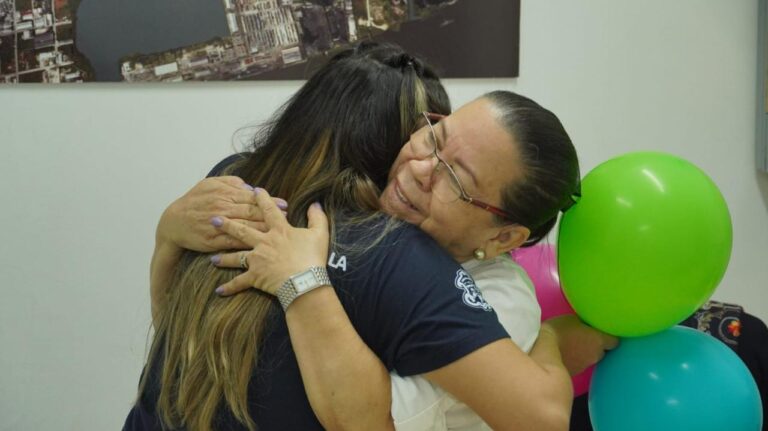 Funcionarias abrazandose en la socialización de campaña Primera Infancia